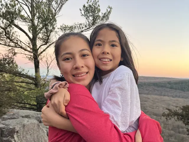 Family photo: two children hugging at sunset