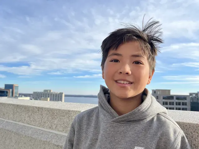 Family photo: child outdoors with a city skyline in the distance