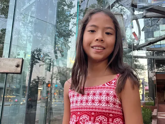 Family photo: child posing outdoors in a red dress