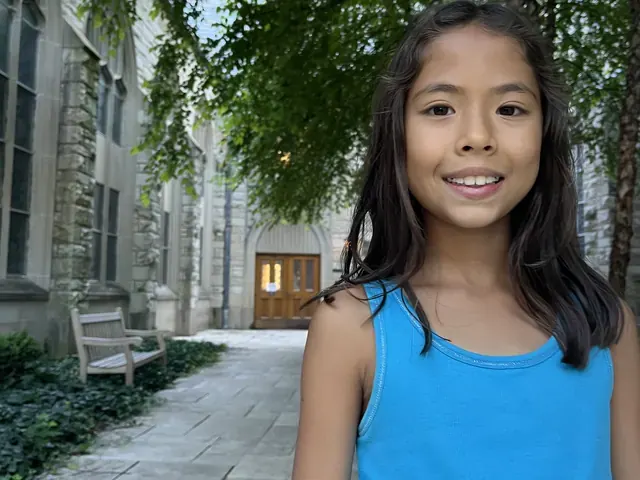 Family photo: child on a tree-lined city sidewalk