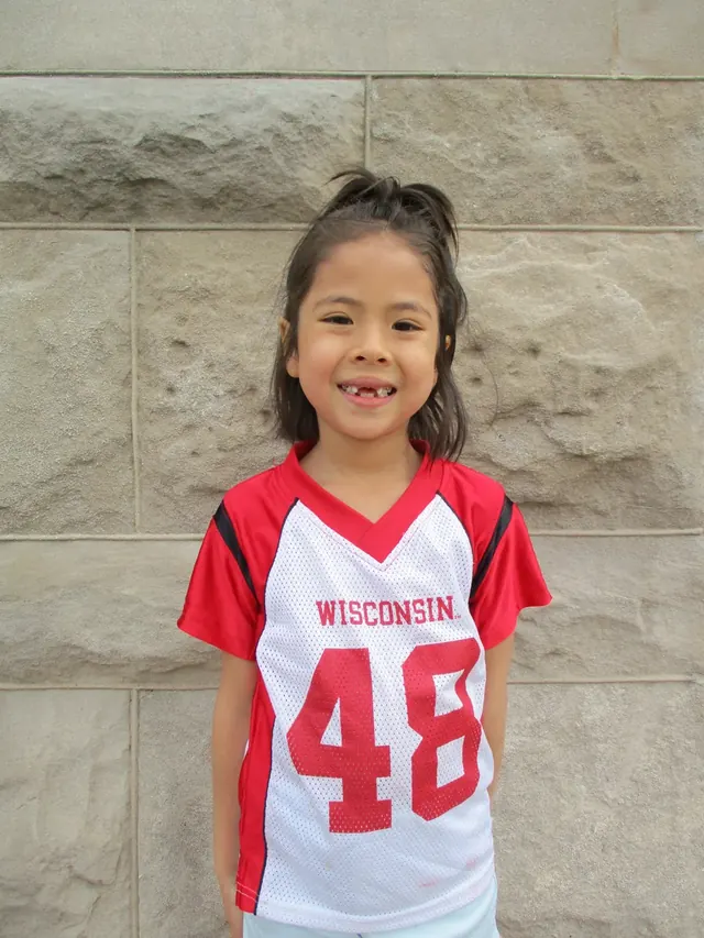 Family photo: child wearing a Wisconsin jersey
