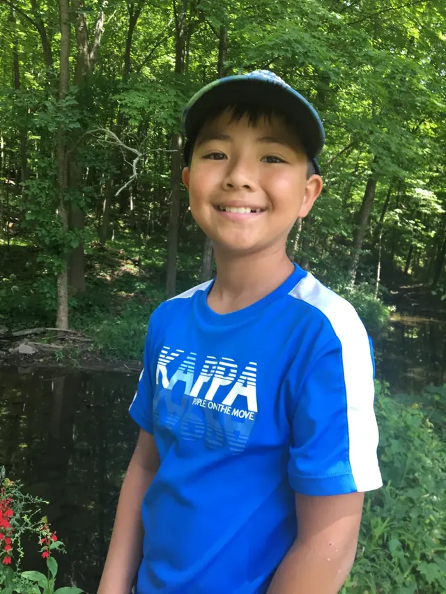 Family photo: young baseball player standing in the woods
